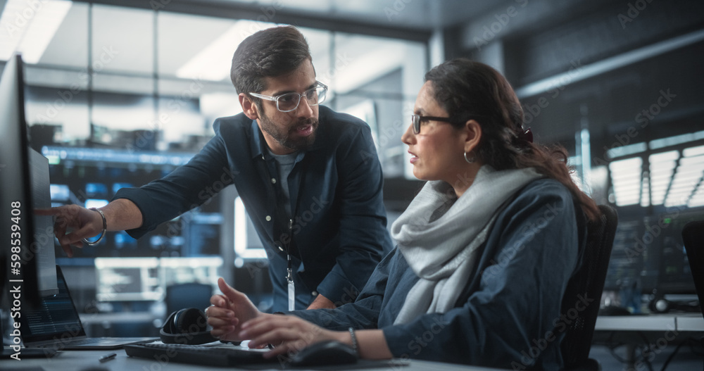 Two Diverse Multiethnic Indian Colleagues Having a Conversation While Busy Working on a Software Development Project. Female Engneer Talking with a Project Manager. Teamwork in Technology Laboratory