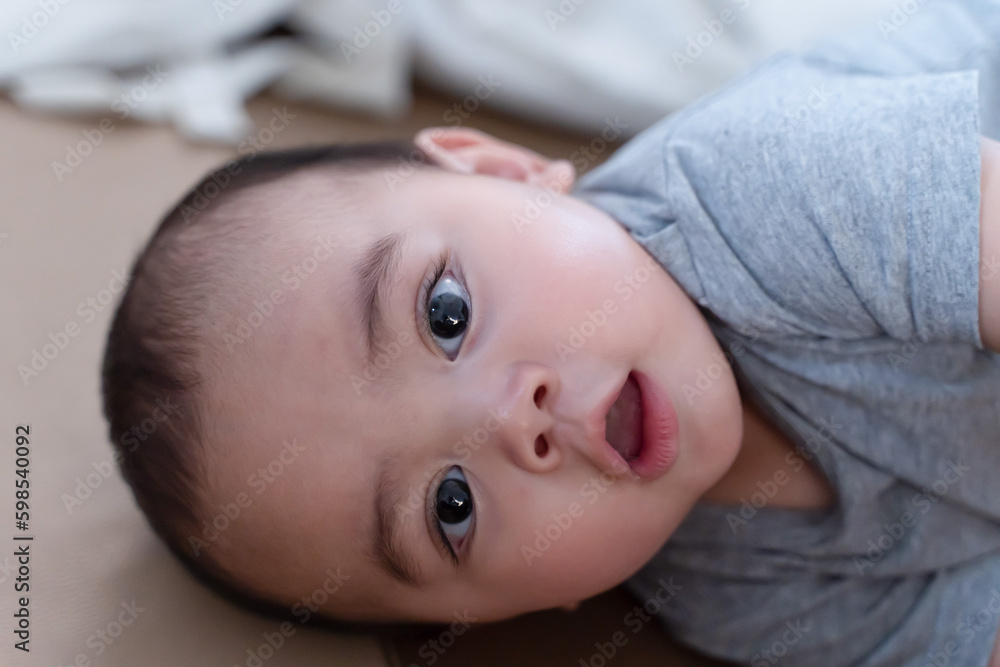 Portrait of a little boy. Close up of happy child on the bed, A child who is intrigued and stares at his surroundings. Portrait of a little boy. Close up of happy child on the bed, A child who is intrigued and stares at his surroundings.