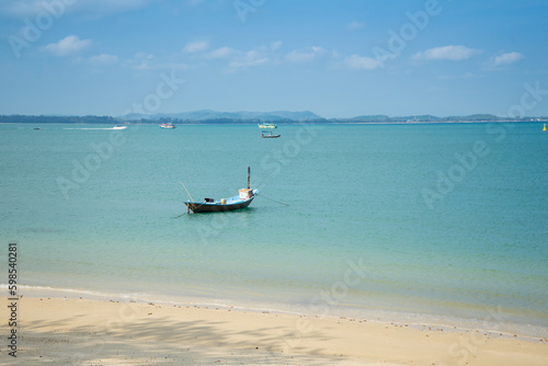 Blue sea water with wooden longtail boat fishing boat on the morning, beautiful sea and island or mountain at Koh Samet Beach in Trat province, Thailand. © sornchai