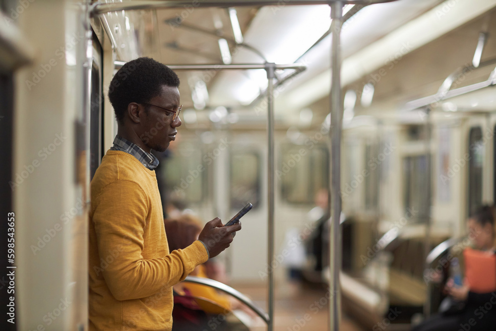 african American man reading online in subway car african American man reading online in subway car