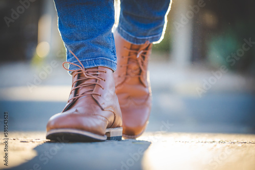 Close up image of a pretty woman with muscular legs wearing handmade leather boots.