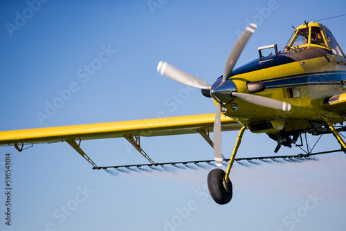 Close up image of crop duster airplane spraying grain crops on a field on a farm photo