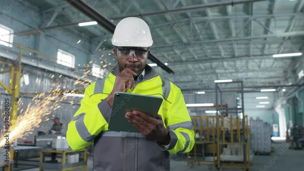African american engineer works with tablet in production. Employee develops new important project plan. Male is developing new strategy for improving manufacturing department. African american engineer works with tablet in production. Employee develops new important project plan. Male is developing new strategy for improving manufacturing department.