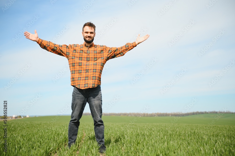 Portrait of farmer in wheat field. A handsome farmer or agronomist is working in the field Portrait of farmer in wheat field. A handsome farmer or agronomist is working in the field