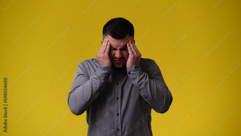 4k video of one man having headache over yellow background. 4k video of one man having headache over yellow background.