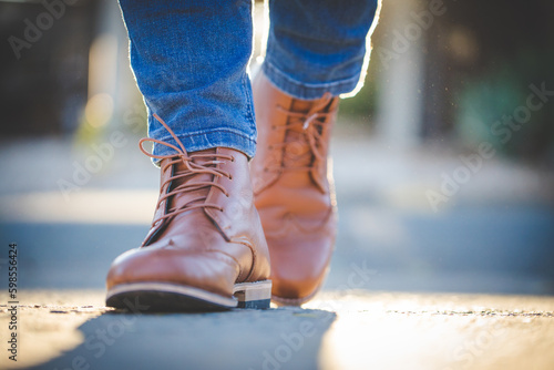 Close up image of a pretty woman with muscular legs wearing handmade leather boots.