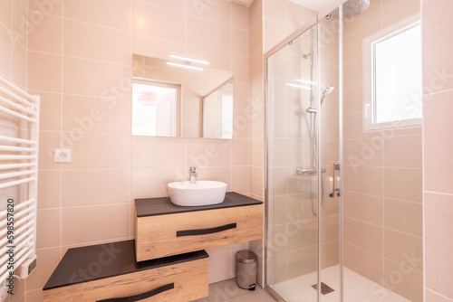 Home bathroom, bright new bathroom interior with tiled glass shower, vanity cabinet, wooden designed interior