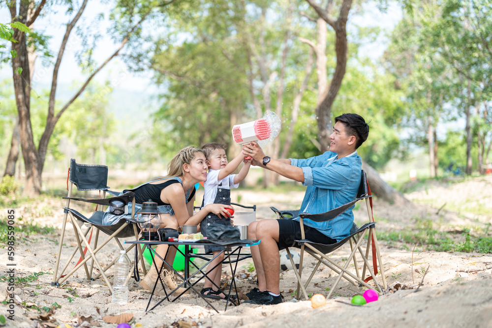 Family enjoying a camping holiday in the countryside ,Camping, travel, tourism, hiking and people. Concept - Happy family with backpacks and thermos at camp. Family enjoying a camping holiday in the countryside ,Camping, travel, tourism, hiking and people. Concept - Happy family with backpacks and thermos at camp.