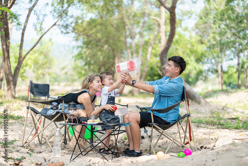 Family enjoying a camping holiday in the countryside ,Camping, travel, tourism, hiking and people. Concept - Happy family with backpacks and thermos at camp.