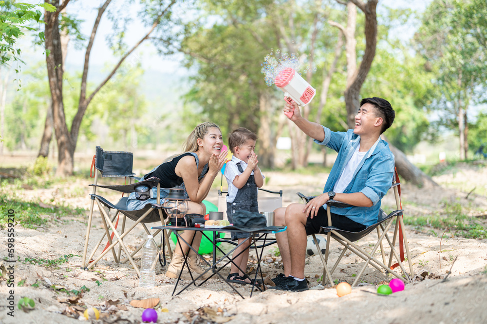 Family enjoying a camping holiday in the countryside ,Camping, travel, tourism, hiking and people. Concept - Happy family with backpacks and thermos at camp. Family enjoying a camping holiday in the countryside ,Camping, travel, tourism, hiking and people. Concept - Happy family with backpacks and thermos at camp.