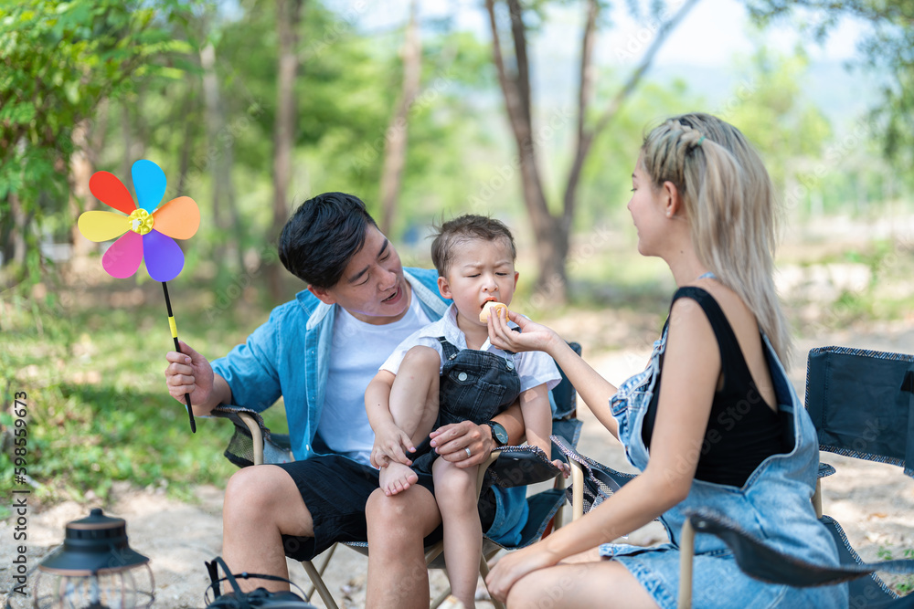 Family enjoying a camping holiday in the countryside ,Camping, travel, tourism, hiking and people. Concept - Happy family with backpacks and thermos at camp. Family enjoying a camping holiday in the countryside ,Camping, travel, tourism, hiking and people. Concept - Happy family with backpacks and thermos at camp.