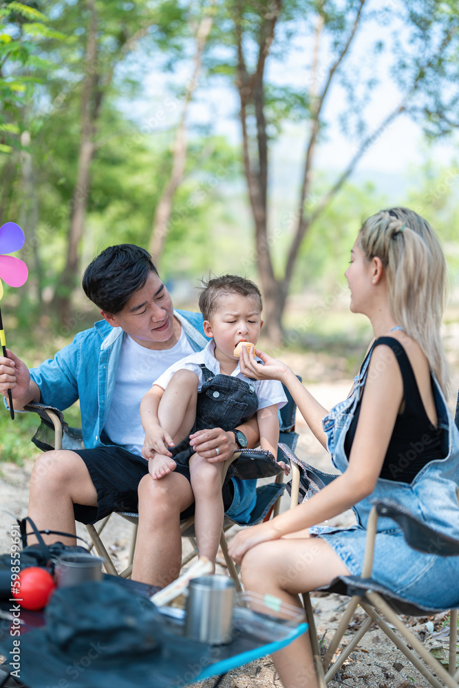 Family enjoying a camping holiday in the countryside ,Camping, travel, tourism, hiking and people. Concept - Happy family with backpacks and thermos at camp. Family enjoying a camping holiday in the countryside ,Camping, travel, tourism, hiking and people. Concept - Happy family with backpacks and thermos at camp.