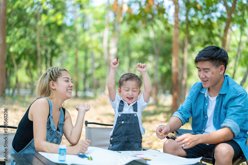 Happy harmonious Asian family park outdoors concept. Mother father and son have activities teaching and learning together on holidays.