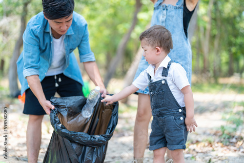 Asian family picking up trash in the forest. Litter cleanup activities. Environment protection. recycling.