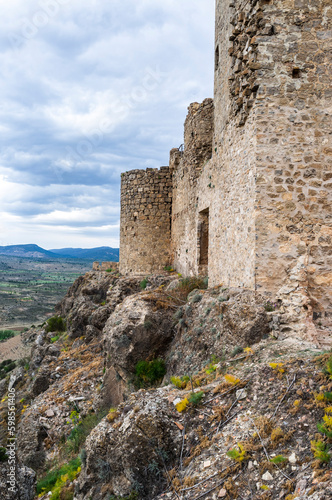 imagen de la pared de piedra de un castillo encima de una montaña de piedra con el cielo nublado  © carles