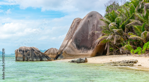 Huge rocks and palm trees by the sea in Anse Source d'Argent beach