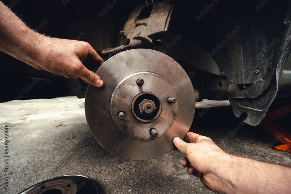 Disk brake and car service concept - Vehicle brake pad replacement service by hand of mechanic man in car, do it yourself, myself. New