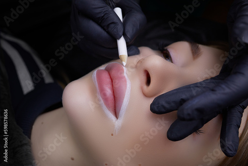 application of a white contour with a pencil on the lips before the procedure of permanent lip makeup