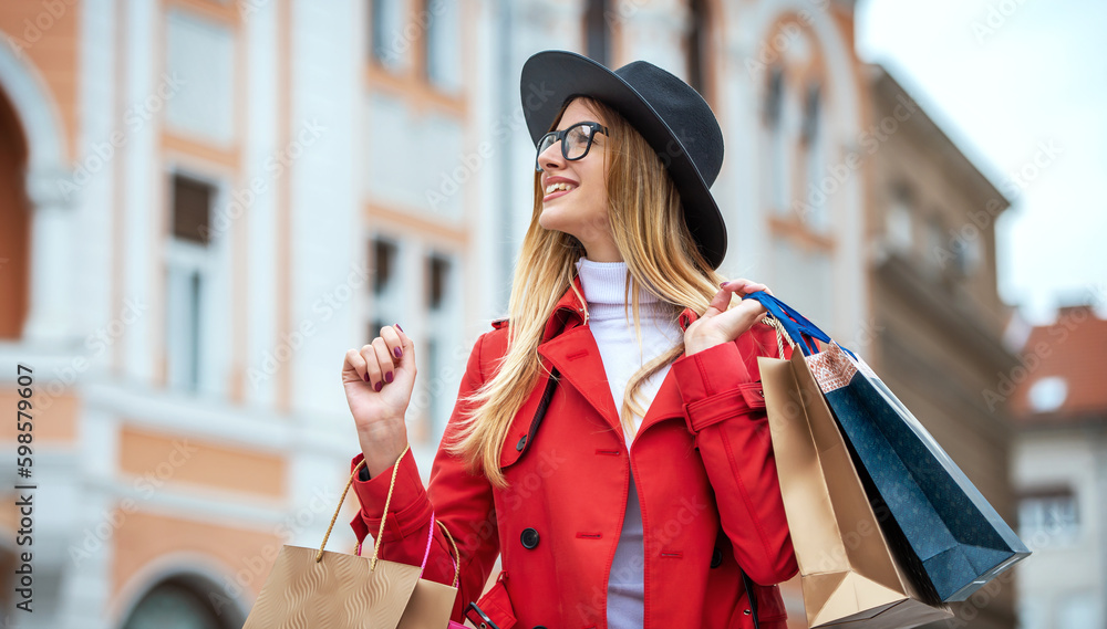 Obraz premium Happy young woman enjoying in shopping. Consumerism, fashion, lifestyle concept
