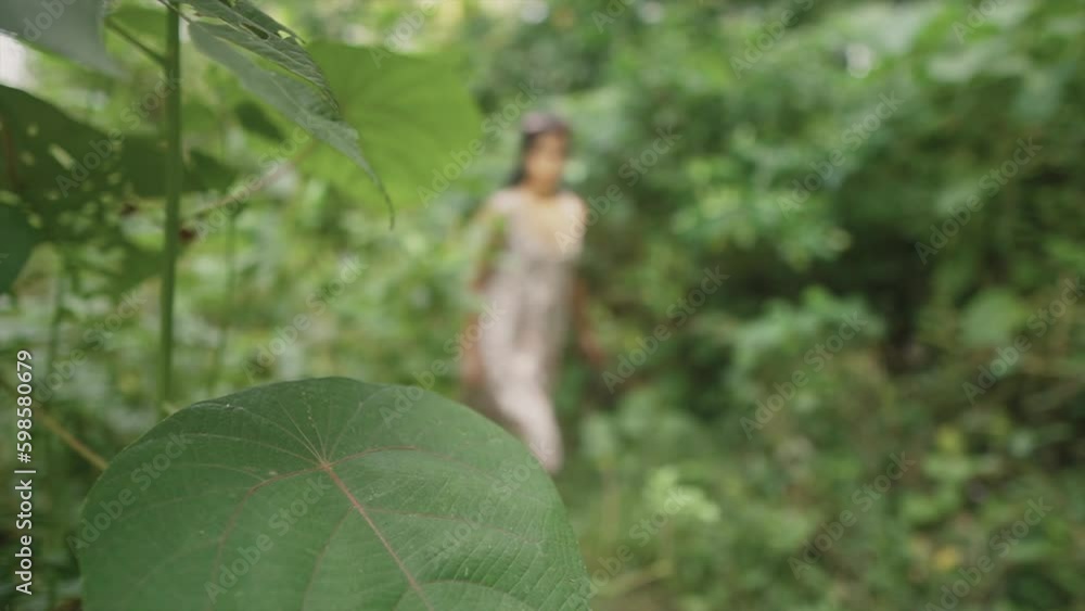 young woman walks in a lush forest, with mixed focus and blur effects, creating a dreamy atmosphere. The camera emphasizes her beauty through a close-up shot. young woman walks in a lush forest, with mixed focus and blur effects, creating a dreamy atmosphere. The camera emphasizes her beauty through a close-up shot.