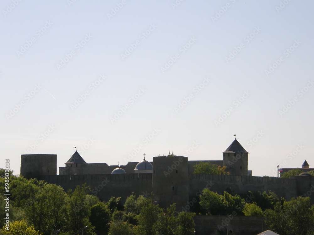 View of the towers and walls of Narva Castle against the blue sky. Leningrad region, Russia.