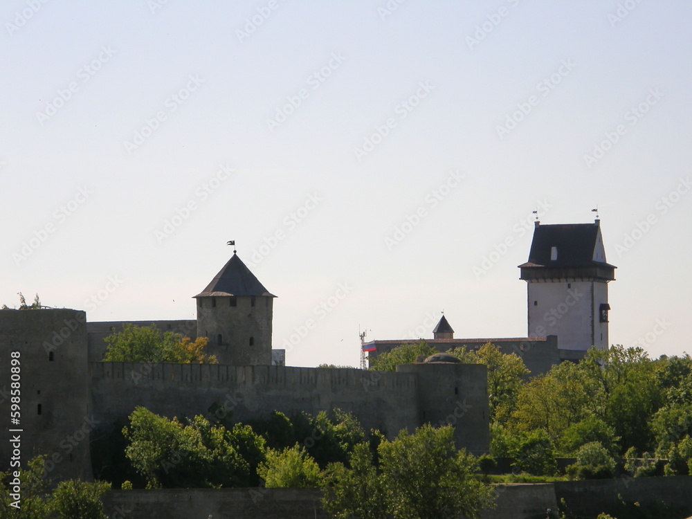 View of the towers and walls of Narva Castle against the blue sky. Leningrad region, Russia.