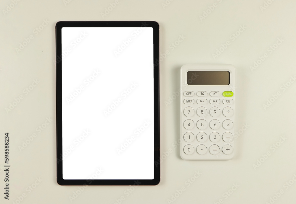 Top view or flat lay of digital tablet with blank white screen, and white calculator isolated on white background. Top view or flat lay of digital tablet with blank white screen, and white calculator isolated on white background.
