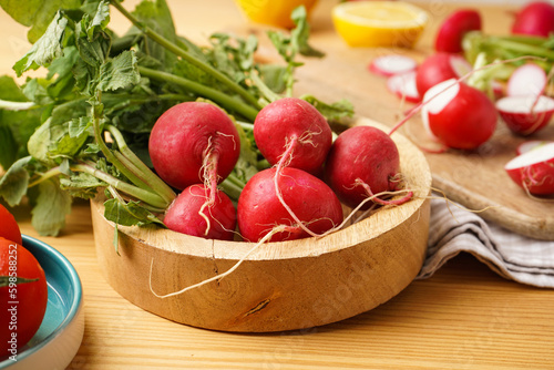 Fresh red radish in bowl on a wooden background. Close-up.
