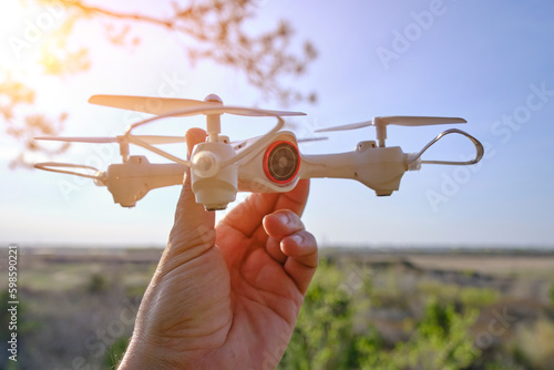 Quadcopter in hand, preparing fly against sky.