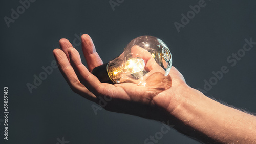 Bright lightbulb held in a hand