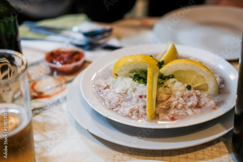 Traditional Peruvian ceviche with white fish, lemons, spicy sauce on a table in a restaurant 