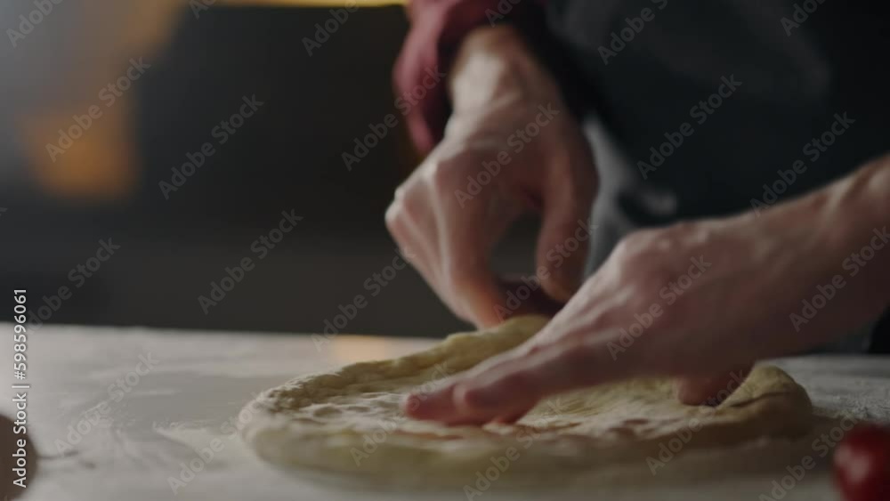 Working with dough, Chef in action preparing pizza Attentively From dough Forms creates a round shape of pizza at the chef's workplace Professional baker Is at the workplace in a diner, bakery
Working with dough, Chef in action preparing pizza Attentively From dough Forms creates a round shape of pizza at the chef's workplace Professional baker Is at the workplace in a diner, bakery