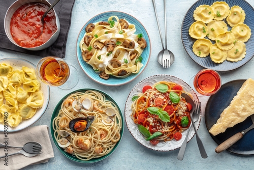 Pasta variety. Italian food and drinks, overhead flat lay shot. Spaghetti marinara, mushroom pappardelle, seafood pasta, wine, Parmesan cheese