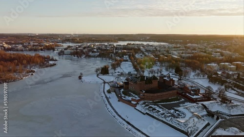 Hame castle and lake Vanajavesi, winter evening in Hameenlinna, Finland - descending, drone shot photo