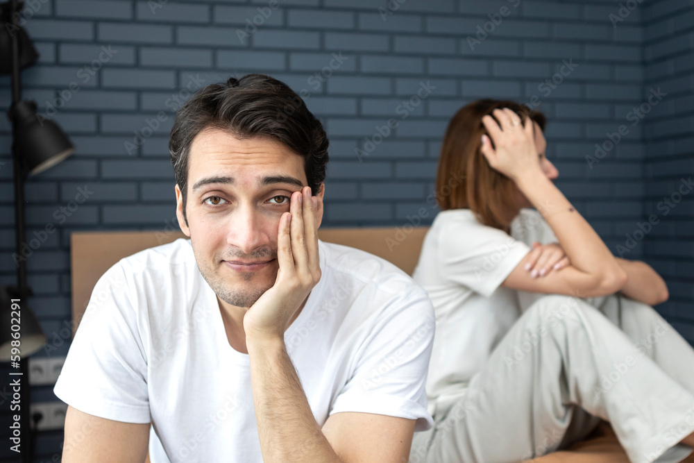 Fototapeta premium Portrait of cheating husband imitating erectile dysfunction and refusing his wife
