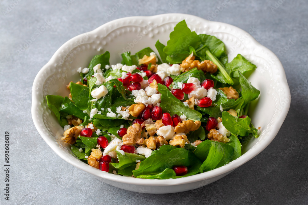 Arugula salad with cheese served with walnuts and pomegranate. Turkish name; Roka salatasi Arugula salad with cheese served with walnuts and pomegranate. Turkish name; Roka salatasi