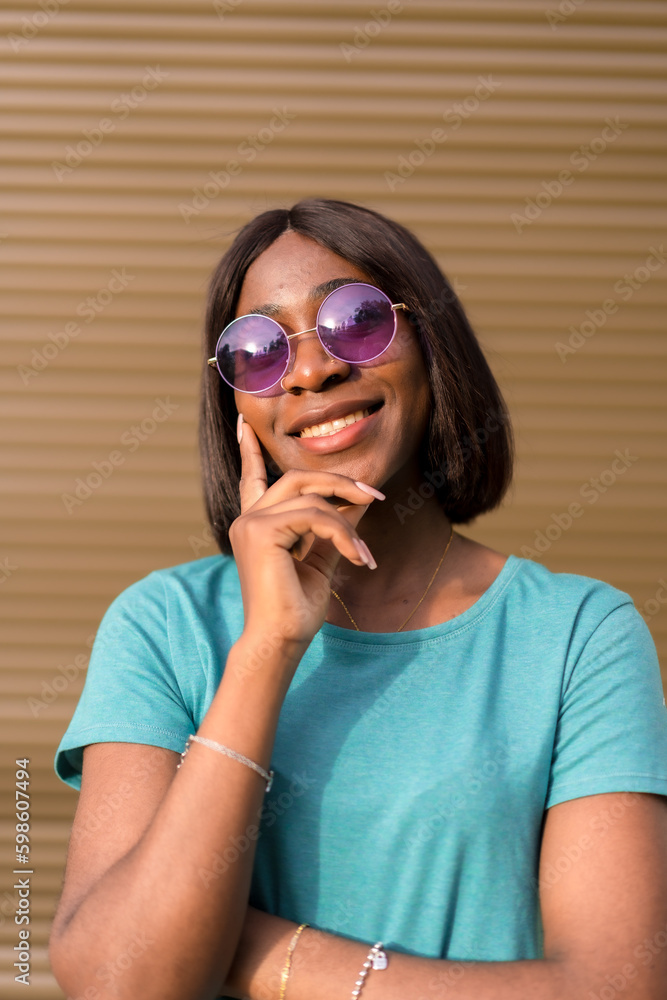 Summer Vibes: A Portrait of a Stylish Black Woman Tourist in Green Tee and Sunglasses Against Brown Wall Summer Vibes: A Portrait of a Stylish Black Woman Tourist in Green Tee and Sunglasses Against Brown Wall