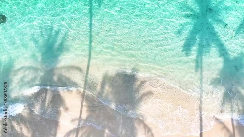 Summer Palm trees shadow on the sandy beach and turquoise Tropical beach with blue background photo