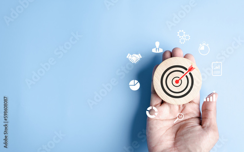 Hand objective focus to target icon which for planning development leadership and customer target group concept...
