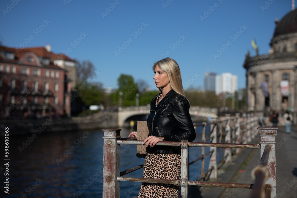 Wunderschöne Frau im Leoparden Muster Kleid spazieren im Sommer an der Spree Berlin
