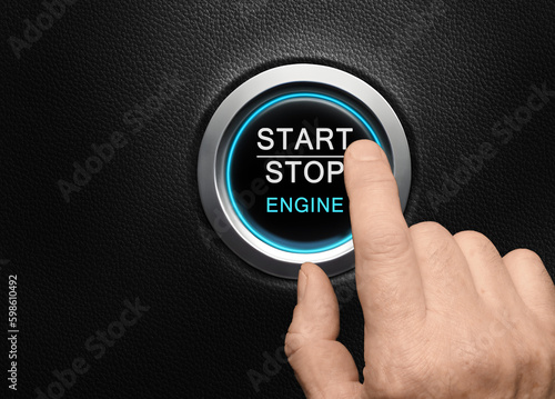 Finger about to press Engine start button with blue glowing ring in a modern car
