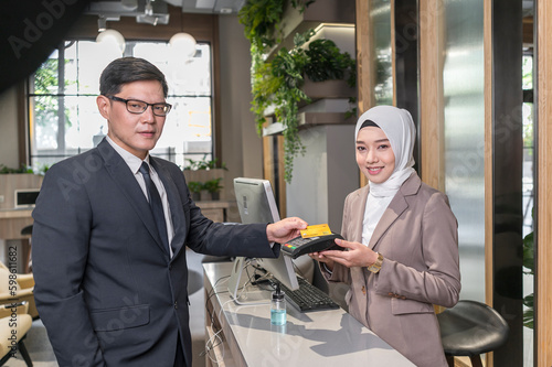 Customer used  wireless credit card  at cashier restaurant counter with smily service - financial technology and cashless concept