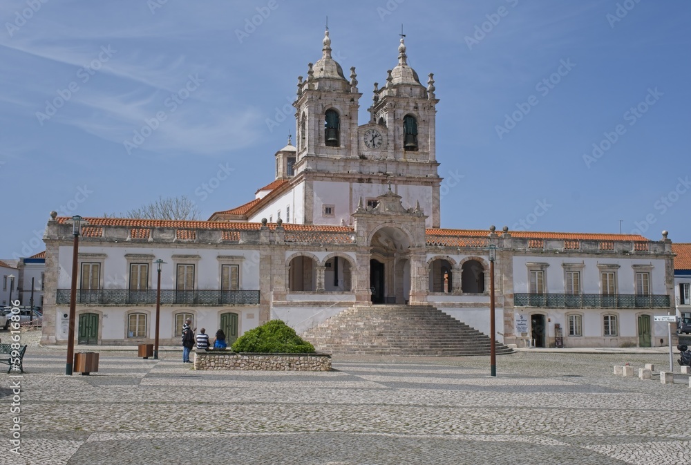 Nazare, Portugal - March 28, 2023: The Sanctuary of Nazare (Santuario de Nossa Senhora da Nazare) is located on the hilltop called O Sitio. 14th century. Sunny spring day. Selective focus