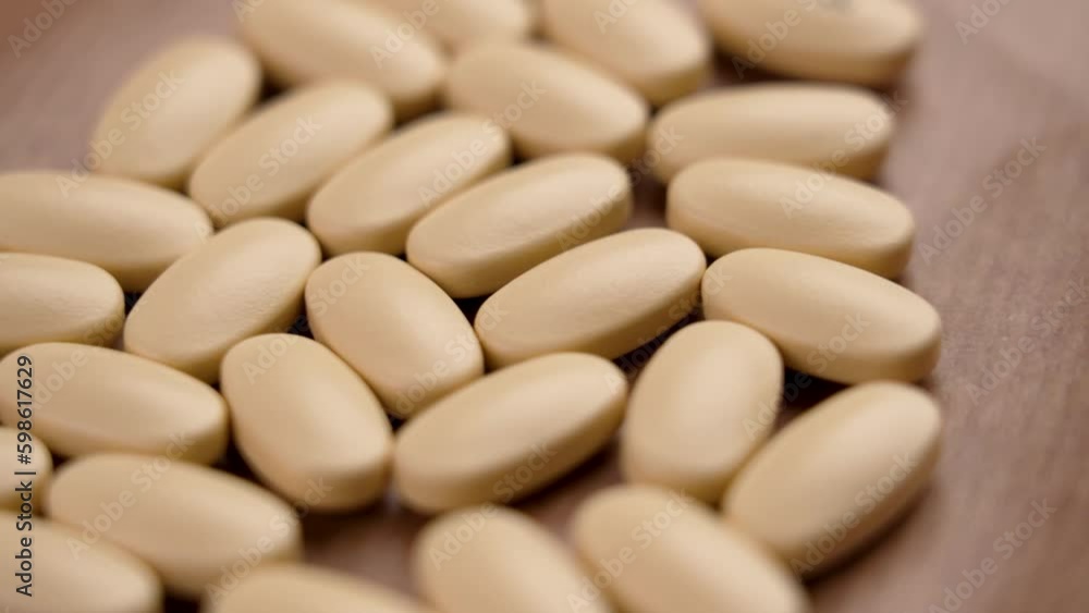Non-steroidal anti-inflammatory NSAID pills on a paper background. Rotation Non-steroidal anti-inflammatory NSAID pills on a paper background. Rotation