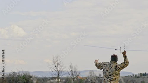 Ukraine Circa spring 2023 - A soldier launches a drone in a field during spring. Back view of the man in military uniform.