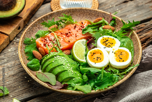 Keto bowl salmon salad with greens, eggs and avocado. Ketogenic diet breakfast lunch. top view