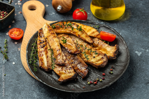 Grilled King oyster mushrooms with thyme on plate. Food recipe background. Close up