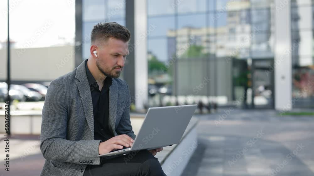 Overjoyed Caucasian Handsome Sitting Outside in Formal Wear, Looking at Laptop Screen, Excited by Unbelievable Good News. Happy Executive Celebrating Receiving Attracted Investment Notification Overjoyed Caucasian Handsome Sitting Outside in Formal Wear, Looking at Laptop Screen, Excited by Unbelievable Good News. Happy Executive Celebrating Receiving Attracted Investment Notification