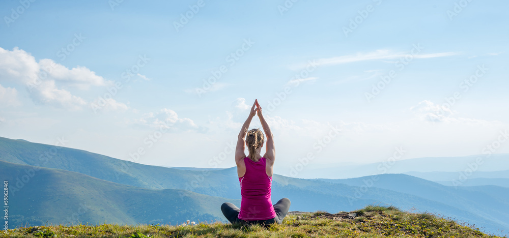 Naklejka premium Young woman on the top of mountain