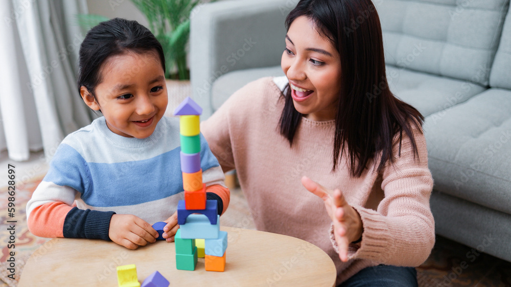 Happy Asian mother and son kid having fun playing together at home living room - Family and love concept - Soft focus on mom face Happy Asian mother and son kid having fun playing together at home living room - Family and love concept - Soft focus on mom face